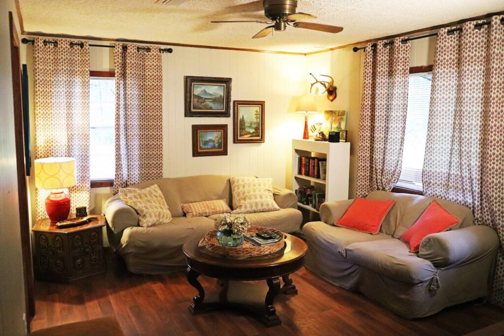 Cottage in the Woods living room with comfortable seating and wood-paneled walls, Drasco AR