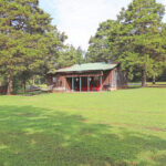 Rear exterior of Cottage in the Woods showing yard and back porch